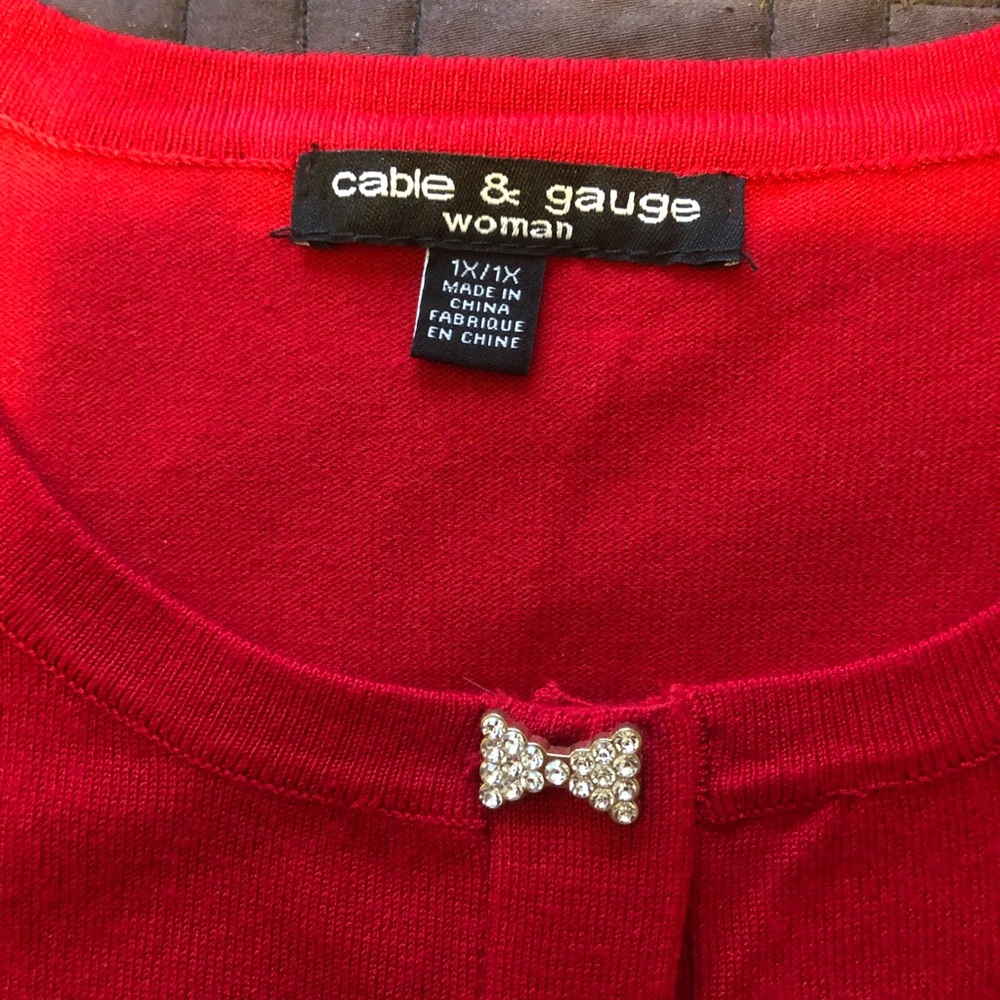Beautiful light weight sweater with 3/4 length sleeves and sparkly bow buttons.